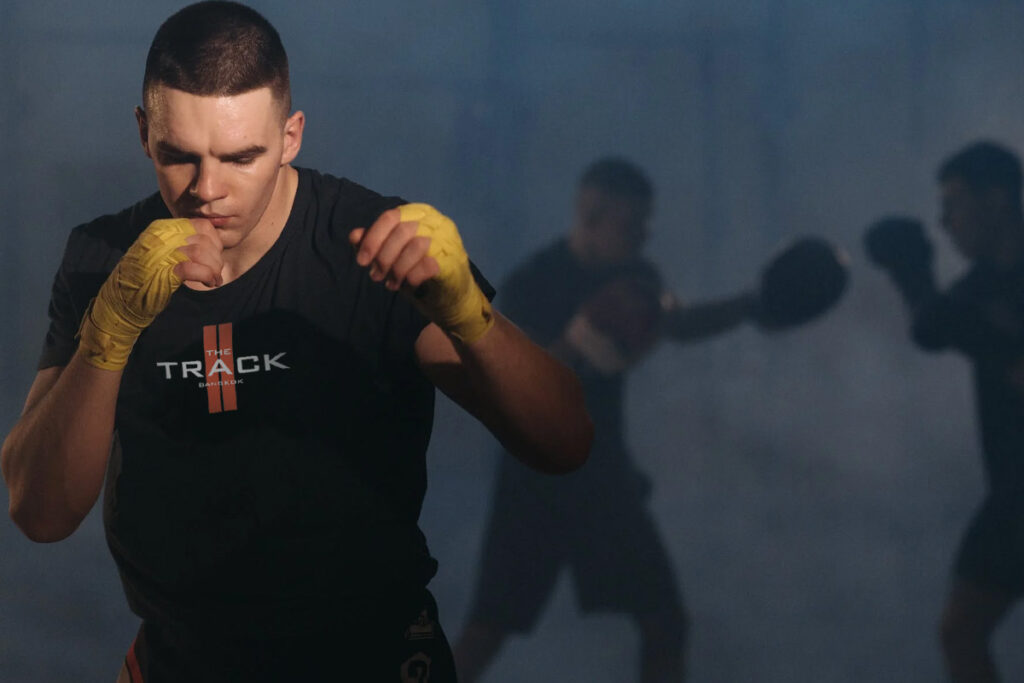 wearing the track tshirt the young is shadow boxing