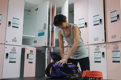young lady preparing footwear and gear for climbing training in gym