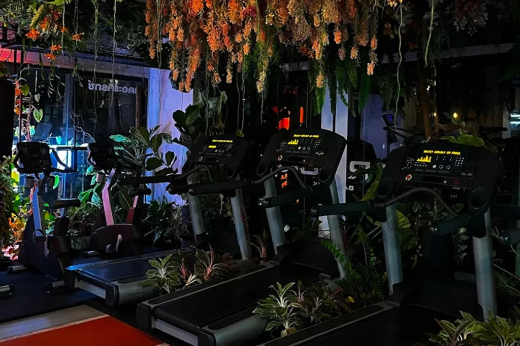 A lush gym at the Track Bangkok, filled with a diverse range of plants and greenery.
